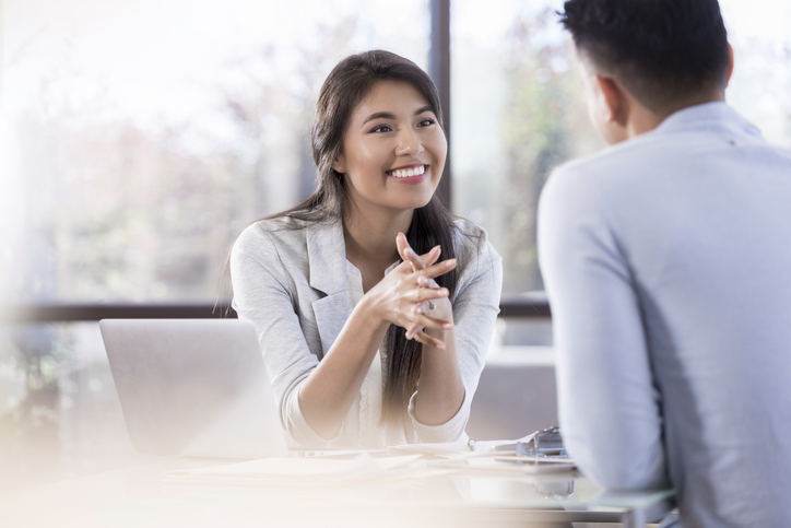 Young female professional smiles at her colleague during meeting